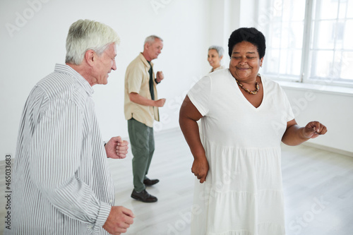 Group of happy senior people dancing together in dance studio
