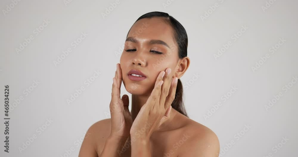 Happy attractive young woman touching pretty face after applying cream do make up Happy attractive young woman touching pretty face after applying cream do make up