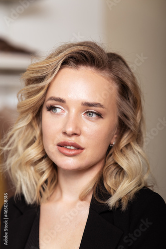 Portrait of young lovely blonde woman with curled hair and make-up for filming. Professional styling, curls and makeup.