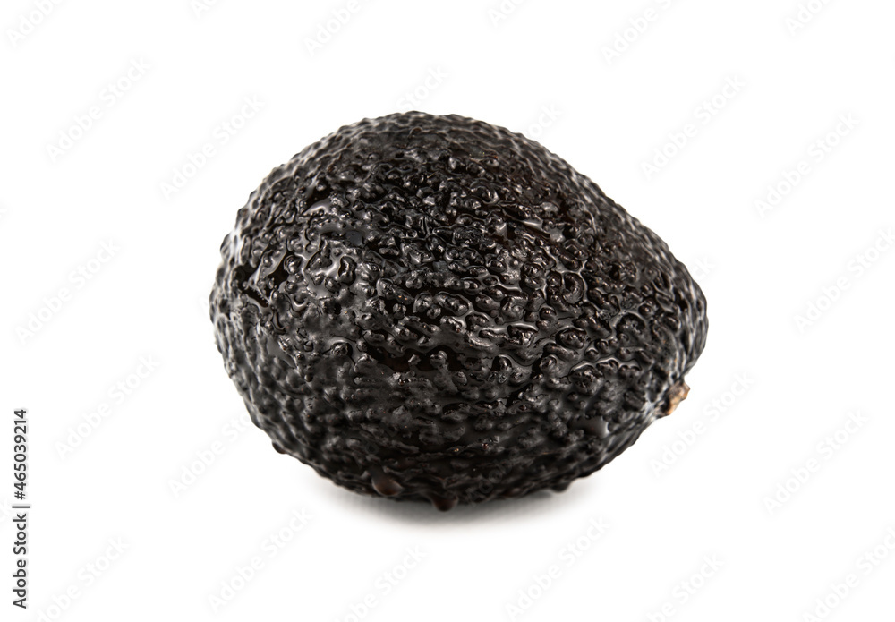 A ripe avocado fruit with a hard, wrinkled skin in droplets of water A ripe avocado fruit with a hard, wrinkled skin in droplets of water