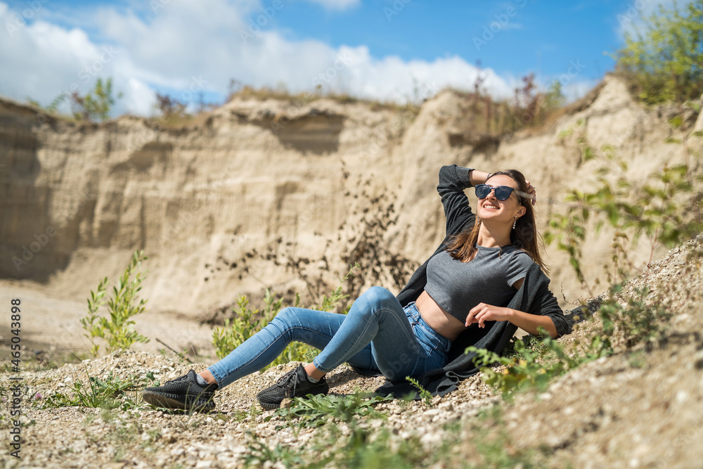 portrait of pretty young woman at nature. summer trip to sand quarry