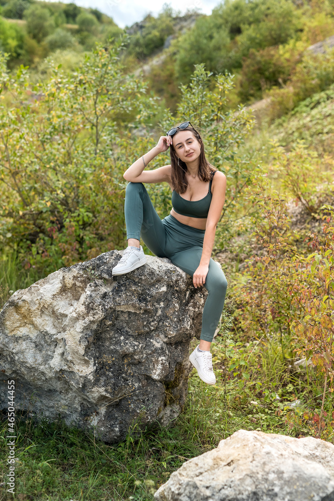 beautiful model girl posing near rocks in sand quarry or mountain