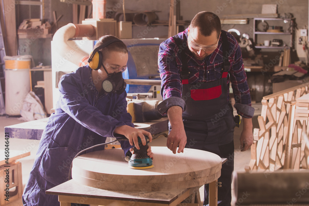 © oksix - Experienced carpenter teaching young apprentice at workshop