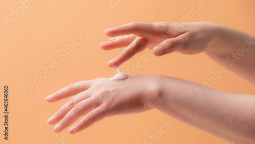 Young female hands applying cream or lotion