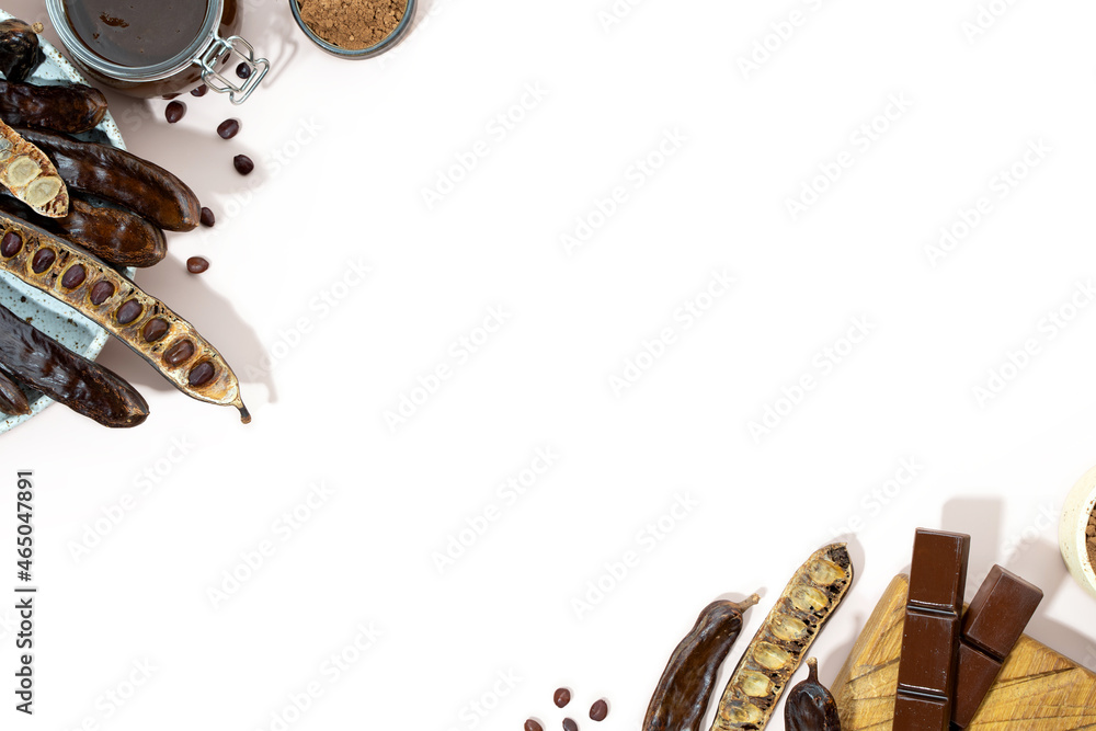 Φωτογραφία Organic carob pods, powder and carob molasses on a beige background, locust bean healthy food, Ceratonia siliqua harnup