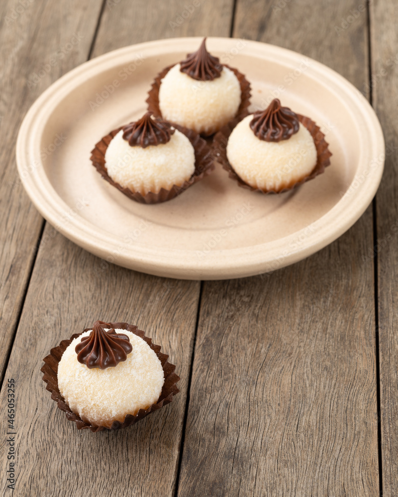 Typical gourmet brazilian brigadeiros, various flavors over wooden table Typical gourmet brazilian brigadeiros, various flavors over wooden table