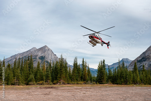 Canvas Print Sightseeing helicopter flying and landing to the ground in Banff national park