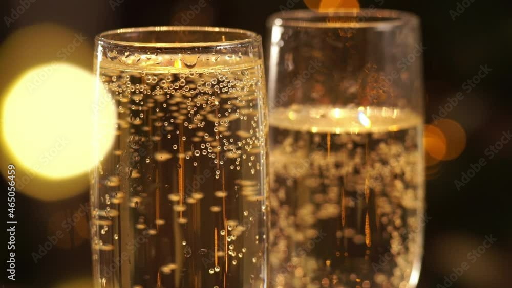 Wine glass of champagne on background of luminous golden blurred lights. Macro bubbles of champagne drink. Christmas, New Year Wine glass of champagne on background of luminous golden blurred lights. Macro bubbles of champagne drink. Christmas, New Year