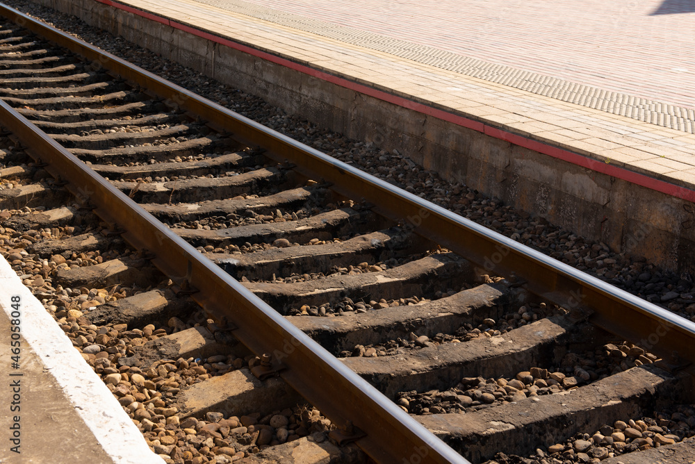 Background of a railway with metal rails and concrete sleepers near the station platform Background of a railway with metal rails and concrete sleepers near the station platform
