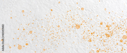 Drops of orange paint on watercolor paper. Abstract texture. Abstract background. 