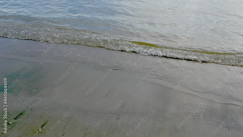 Soft sea waves splashing on a sandy golden-colored beach Soft sea waves splashing on a sandy golden-colored beach