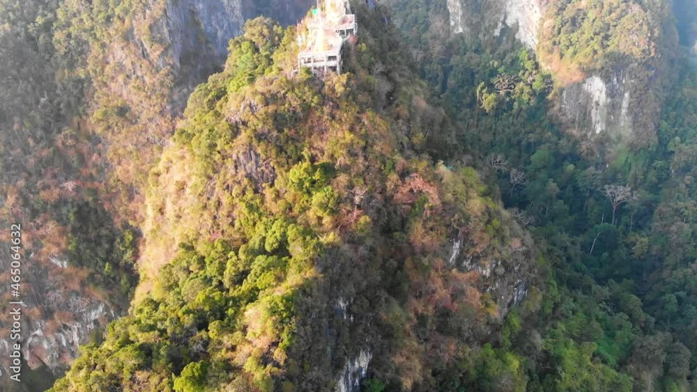 Slow Upwards Revealing Aerial Drone Shot of Wat Tham Suea (Tiger Cave Temple), Going Over The Golden Buddha At Sunset in The Thai Province of Krabi - Thailand Slow Upwards Revealing Aerial Drone Shot of Wat Tham Suea (Tiger Cave Temple), Going Over The Golden Buddha At Sunset in The Thai Province of Krabi - Thailand