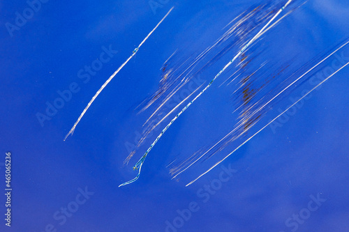 Huge scratches on a blue car. Vehicle damaged by vandals. Closeup.