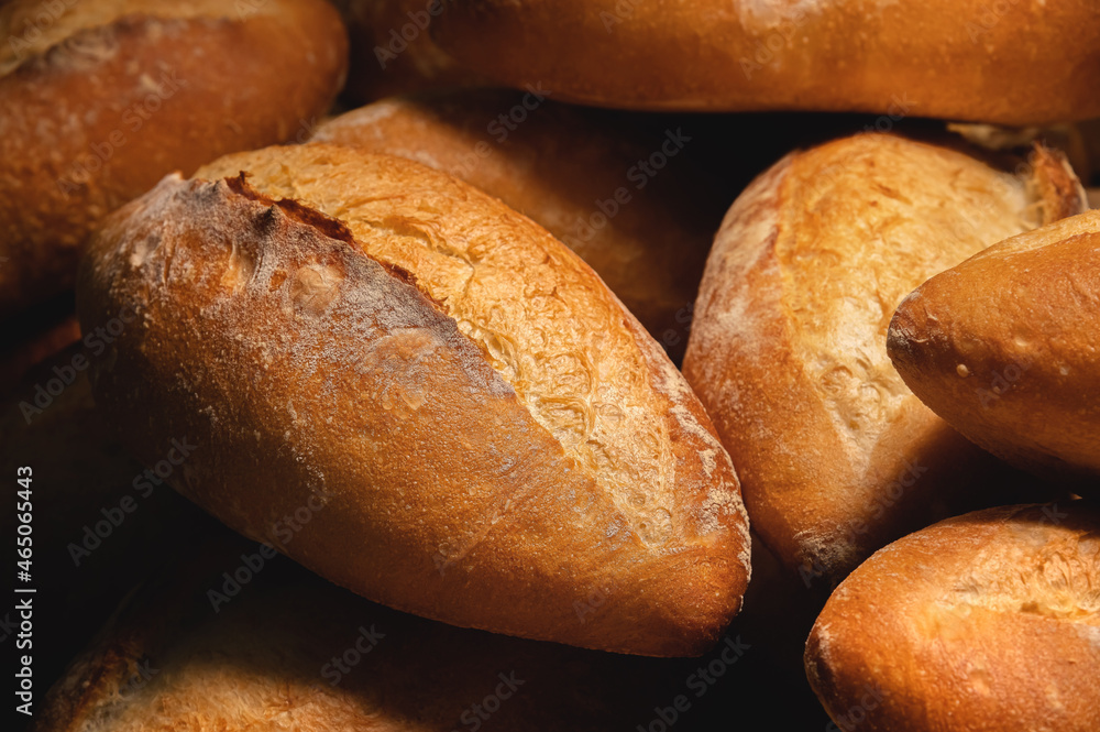Close-up of sourdough bread. Freshly baked bread with a golden crust on the wooden shelves of the bakery. The context of a German artisan bakery with an assortment of rustic breads.