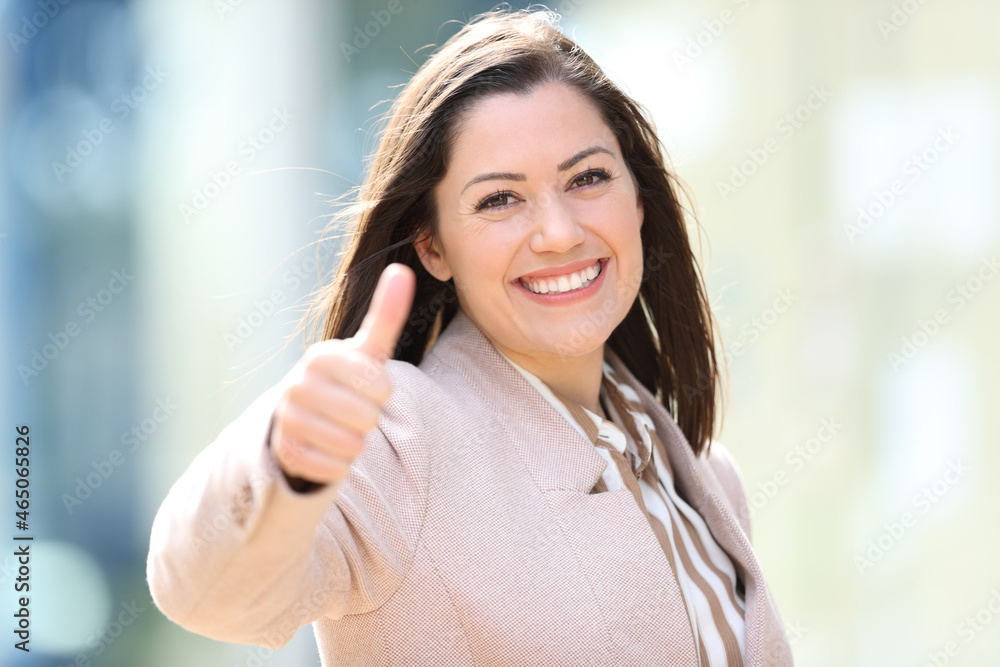 Happy businesswoman in the street with thumbs up Happy businesswoman in the street with thumbs up