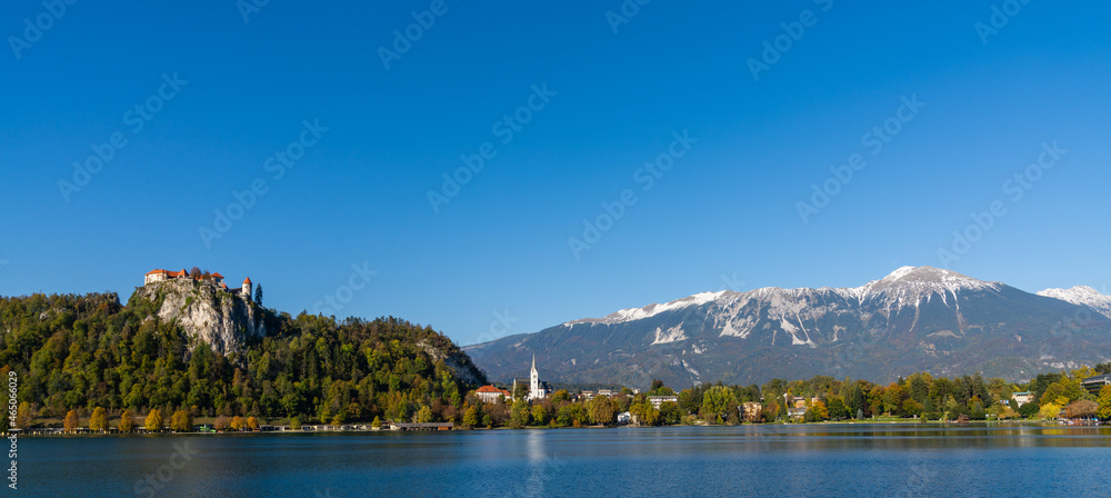 view of Lake Bled with the Bled Castle and village in autumn and snow-covered Julian Alps in the background view of Lake Bled with the Bled Castle and village in autumn and snow-covered Julian Alps in the background