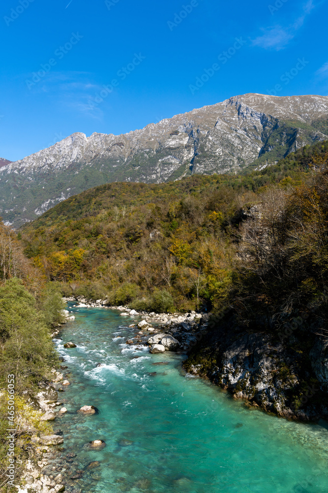 beautiful autumn color landscape in the Julian Alps of Slovenia with the clear turquoise Soca river in the foreground