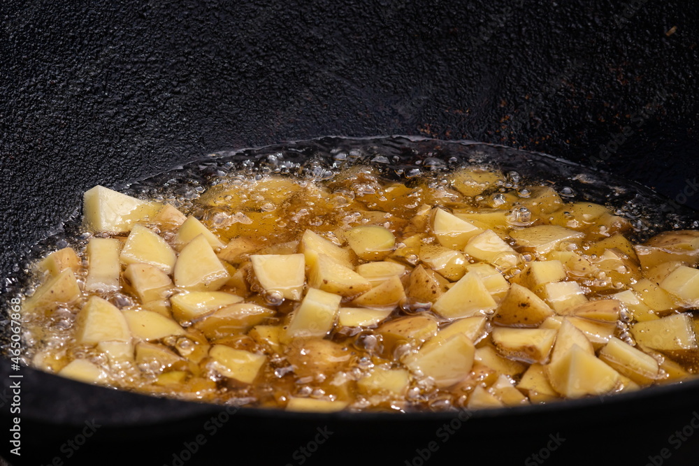 street food. fried potatoes. the process of cooking fried potatoes. potatoes are fried in a huge frying panstreet food street food. fried potatoes. the process of cooking fried potatoes. potatoes are fried in a huge frying panstreet food