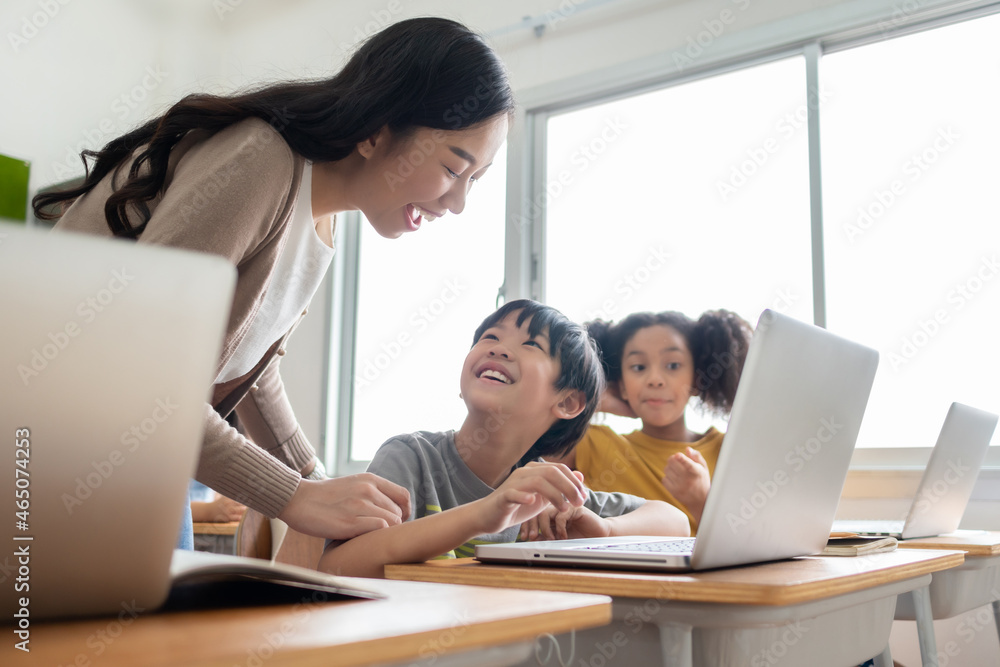 Happy Smiling Asian female teacher is teaching and advice her Asian boy learning on laptop. Happy Smiling Asian female teacher is teaching and advice her Asian boy learning on laptop.