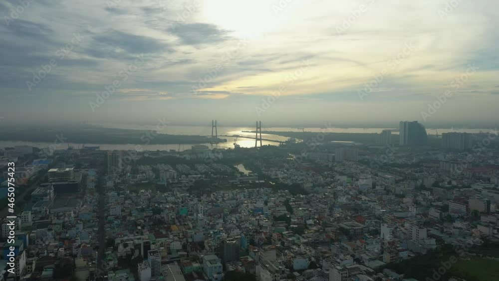 Fly in over urban area towards river and large modern suspension bridge in early morning light part one Fly in over urban area towards river and large modern suspension bridge in early morning light part one