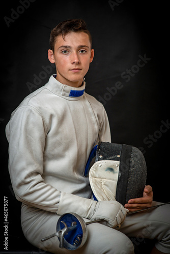 A young swordsman in ammunition and with a sword in his hand