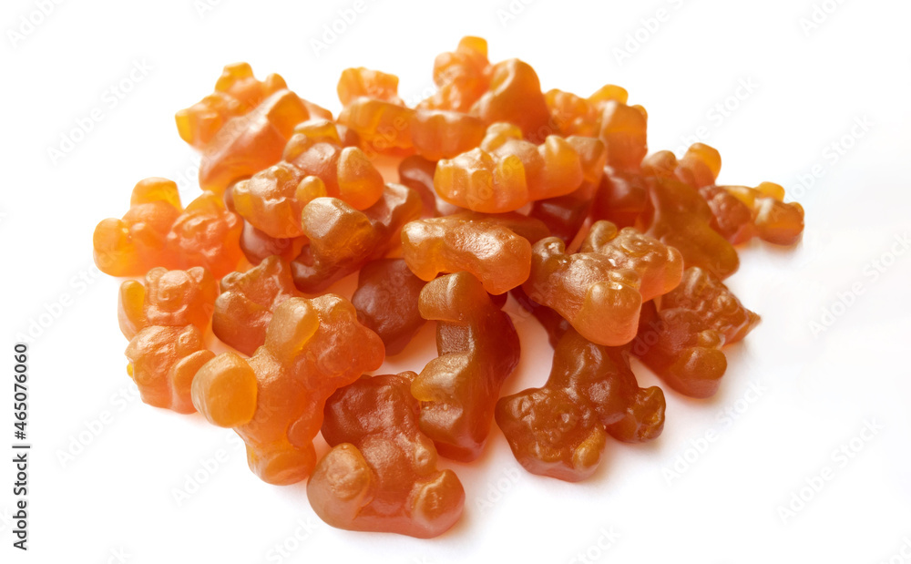 Close-up texture of orange and yellow multivitamin gummies in the form of bears on white background. Close-up texture of orange and yellow multivitamin gummies in the form of bears on white background.