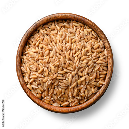 Wholegrain spelt farro in wooden bowl isolated on white background. View from above. photo