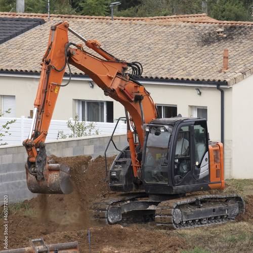 Travaux de terrassement avec une pelleteuse sur le chantier de construction d'une maison photo