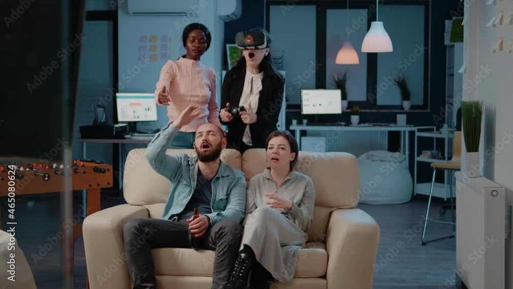 Woman playing video games with joystick and vr glasses, losing game play while colleagues cheering to do fun activity after work. Coworkers enjoying game on console television with entertainment Woman playing video games with joystick and vr glasses, losing game play while colleagues cheering to do fun activity after work. Coworkers enjoying game on console television with entertainment