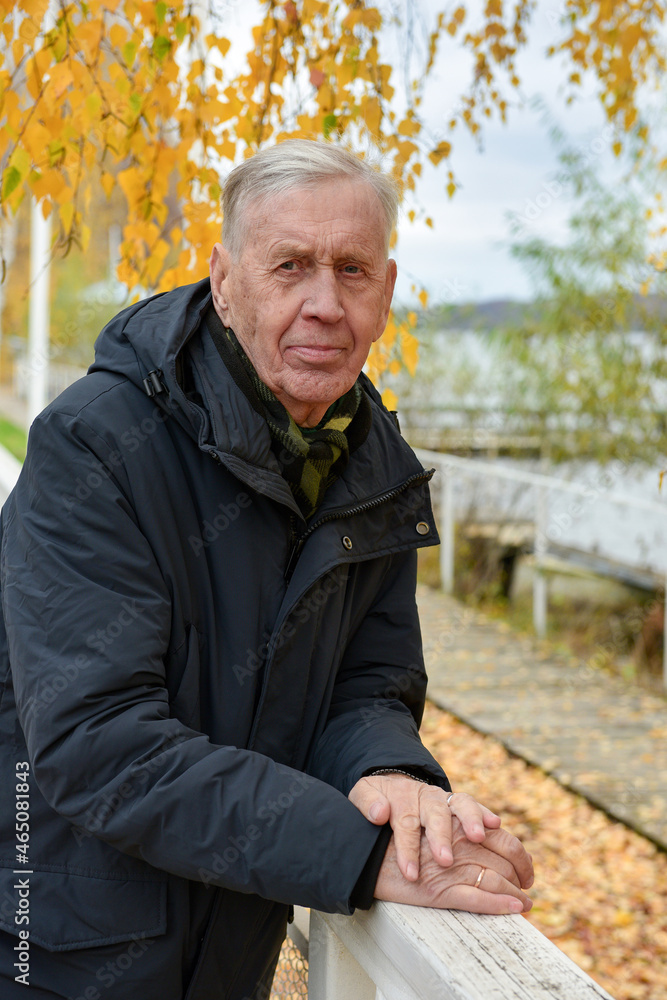 Portrait of a handsome old man in a warm jacket in the fall, on a cloudy day. Portrait of a handsome old man in a warm jacket in the fall, on a cloudy day.