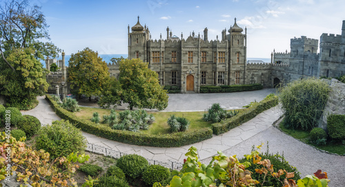 Vorontsov Palace in Alupka, Crimea. Panoramic view of castle with blue sky background. Yucca bushes and trees are in foreground