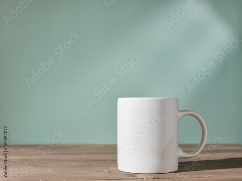 Cup on the table against the background of a green wall