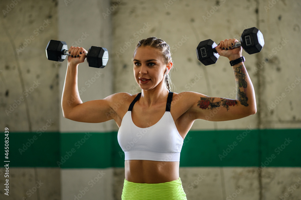 Woman training outside while using dumbbells and airpods Woman training outside while using dumbbells and airpods