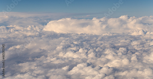 Stratosphere, a view of clouds from an airplane window. Cumuliform cloudscape on sky. Flying over the land. © Piotr
