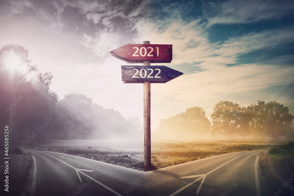 Conceptual scene choose road 2022 year or 2021. Split ways and signpost arrows showing two different courses, left and right Go ahead to the future or turn back to past. Life decision and choice - obrazy, fototapety, plakaty 