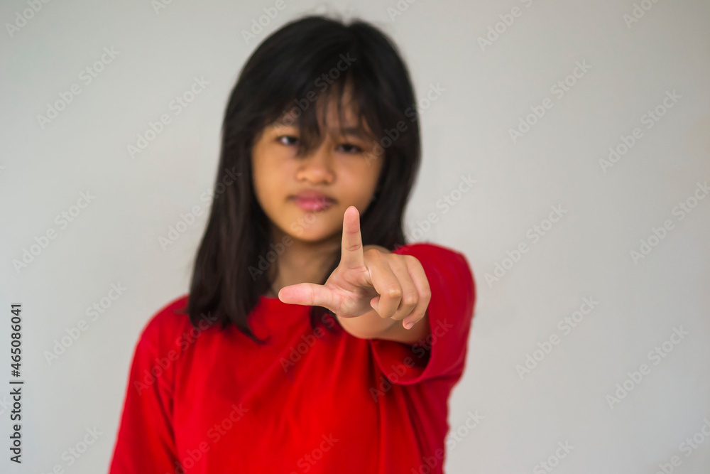 A young beautiful girl pointing with her index finger. A young beautiful girl pointing with her index finger.