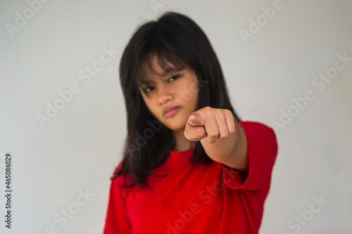 A young beautiful girl pointing with her index finger. © ismed