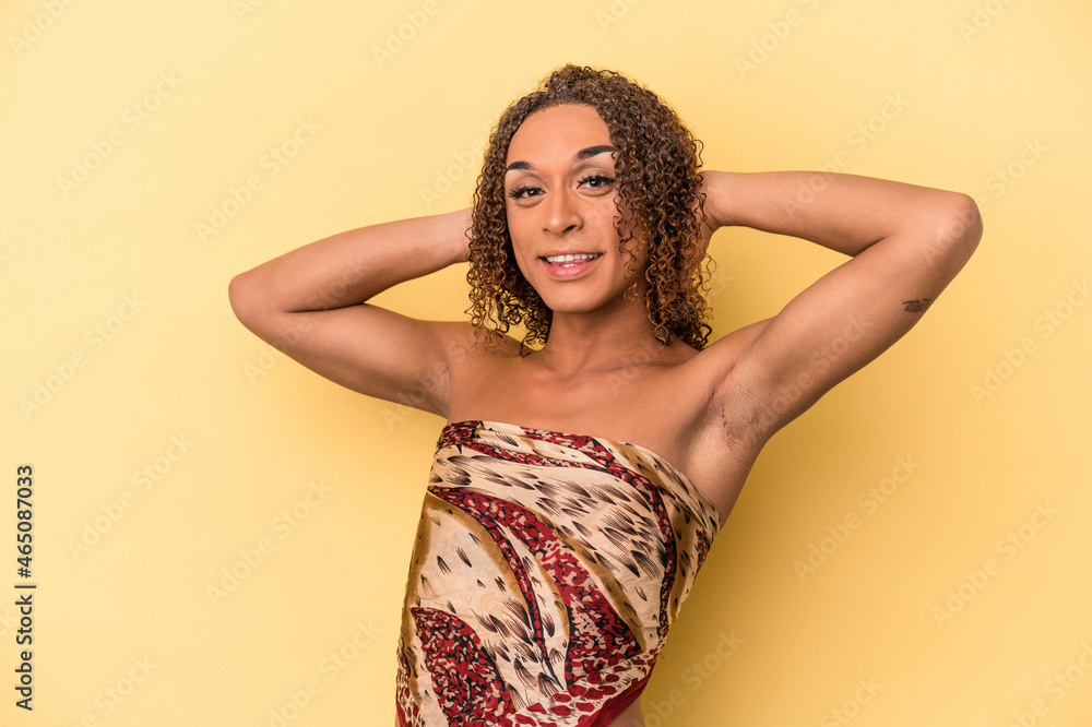 Young latin transsexual woman isolated on yellow background stretching arms, relaxed position. Young latin transsexual woman isolated on yellow background stretching arms, relaxed position.