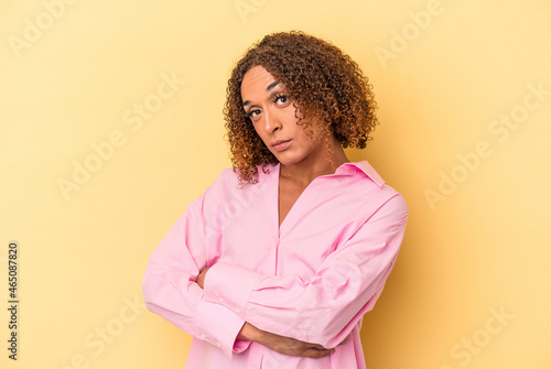 Young latin transsexual woman isolated on yellow background unhappy looking in camera with sarcastic expression.