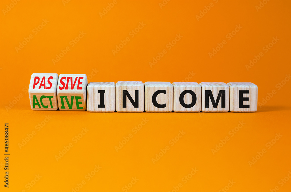 Passive or active income symbol. Turned cubes and changed words passive income to active income. Beautiful orange background, copy space. Business, passive or active income concept.