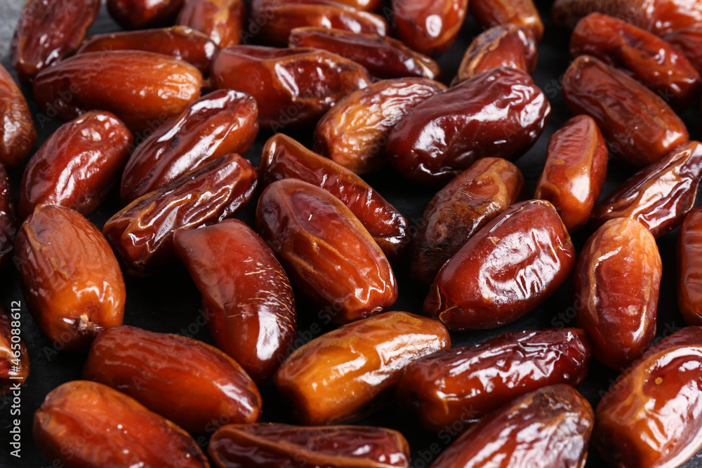 Many sweet dried dates on dark grey background, closeup Many sweet dried dates on dark grey background, closeup