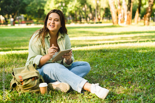 Caucasian young freelancer woman student doing homework, e-learning, preparing for test exam, writing poems novels relaxing on college university lawn park
