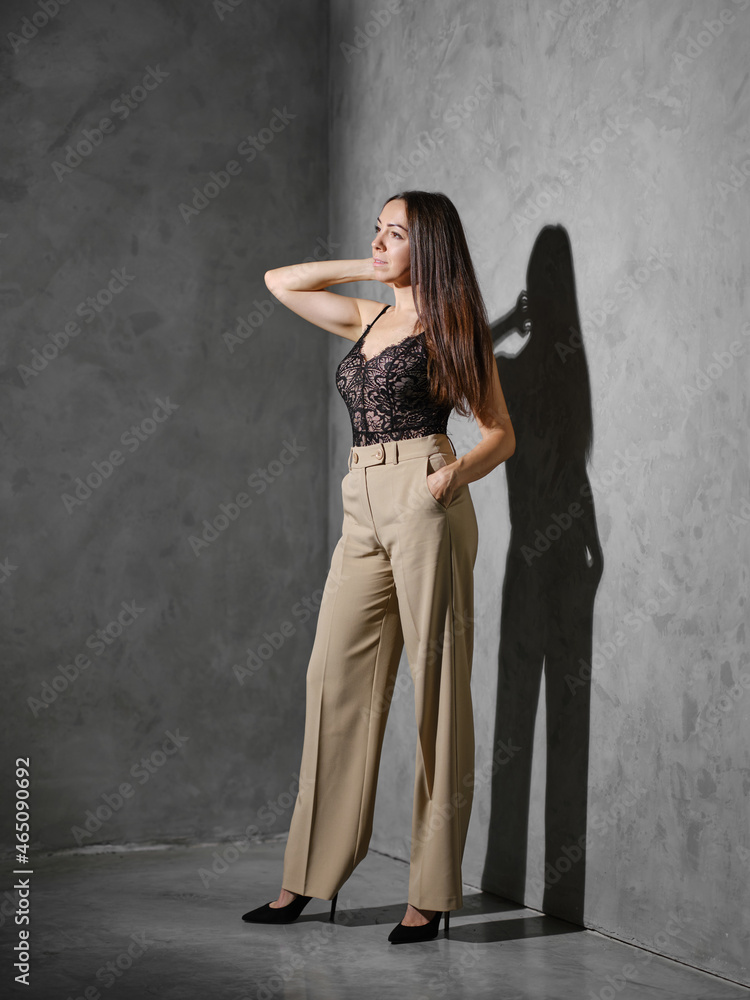 Middle age woman in wide trousers standing in the corner Middle age woman in wide trousers standing in the corner