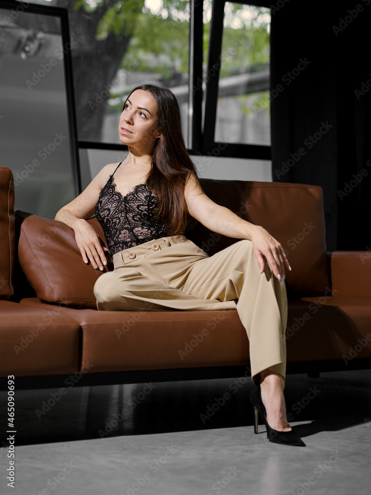Middle age woman sitting on the sofa and looking to the side Middle age woman sitting on the sofa and looking to the side