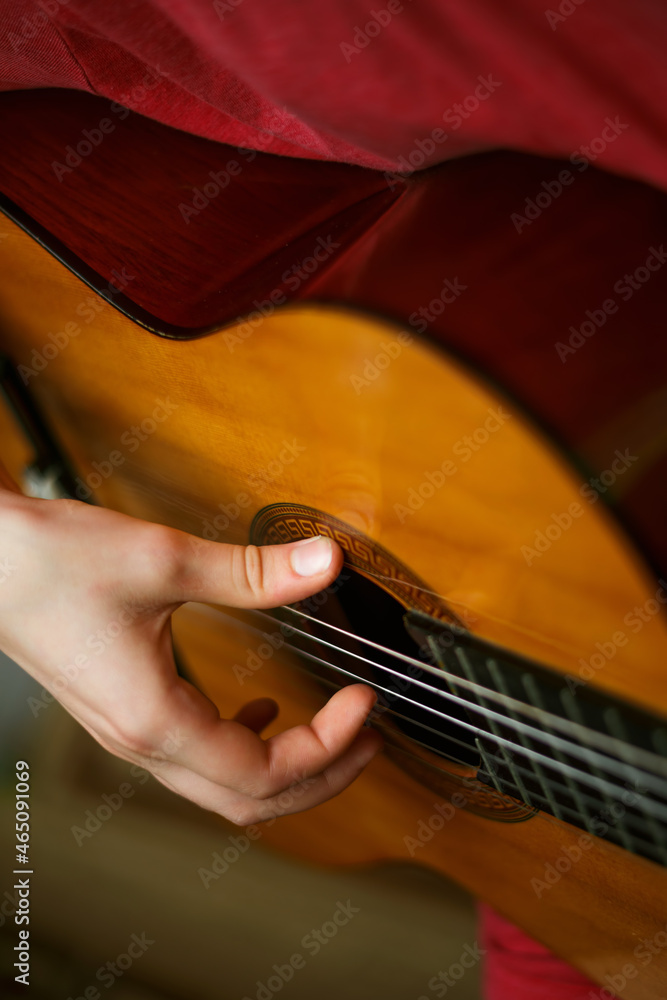 Fototapeta premium Kids hands on guitar strings. Playing guitar