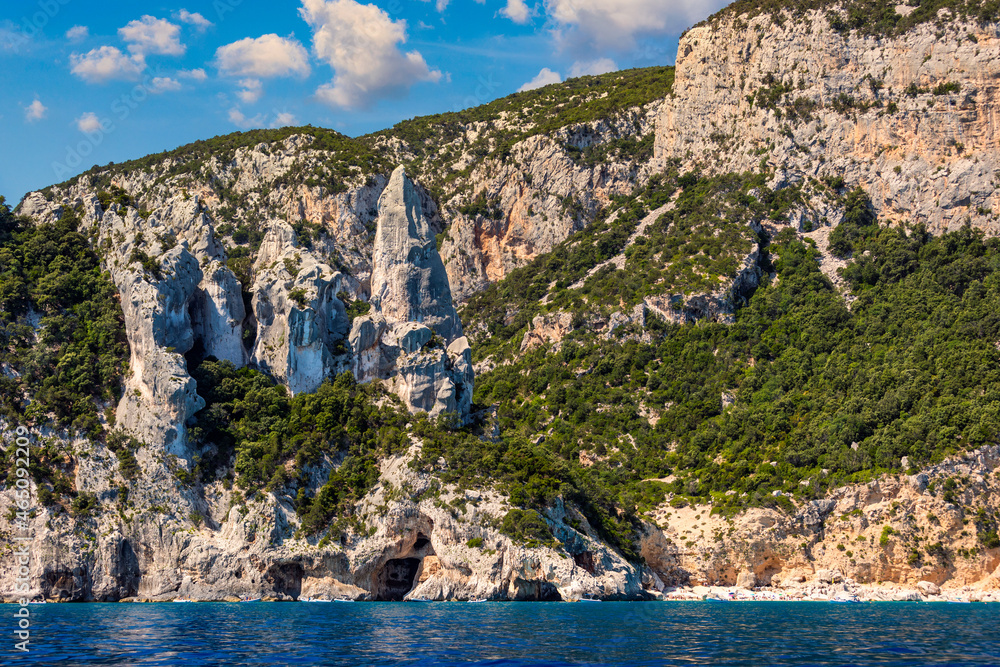 Blue sea and the characteristic caves of Cala Luna, a beach in the Golfo di Orosei, Sardinia, Italy. Big sea caves in the mediterranean coast. Sardinia, Italy.
