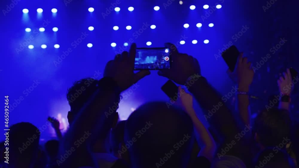 Crowd cheering on a music festival. Focus on dancing people recording with smart phones Crowd cheering on a music festival. Focus on dancing people recording with smart phones