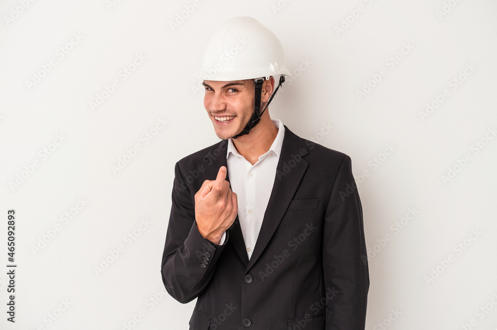 Young architect caucasian man isolated on white background pointing with finger at you as if inviting come closer.