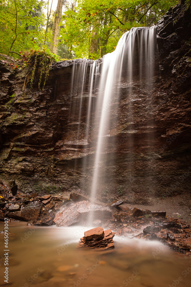 Obraz premium Waterfall cascade flowing over a rock