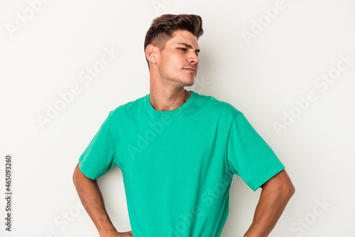 Young caucasian man isolated on white background dreaming of achieving goals and purposes